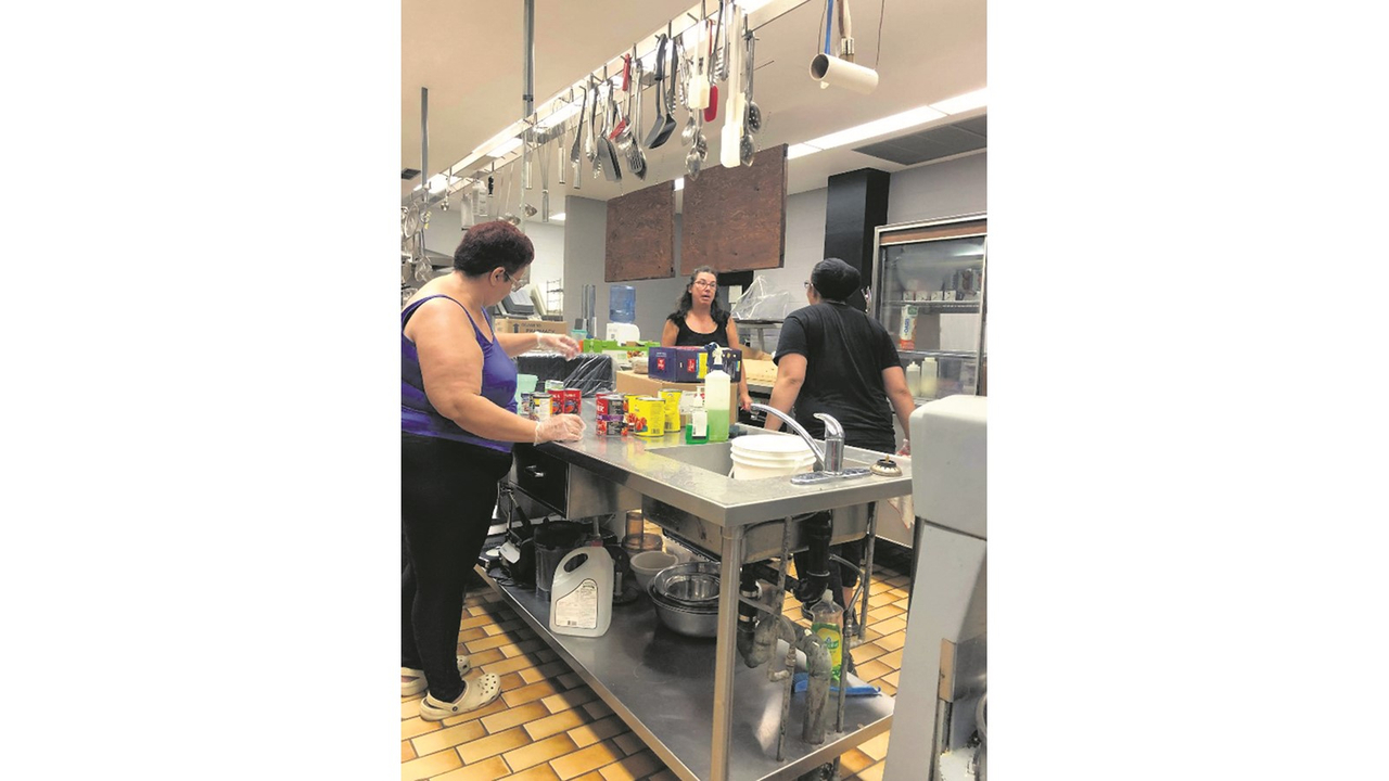 Mme Denise Proulx et des membres de l’équipe durant la préparation de repas.