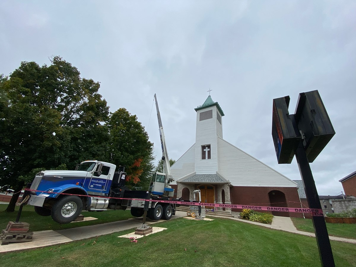 Des travaux de peinture ont nécessité l’utilisation d’une grue pour qu’on puisse atteindre le clocher de façon sécuritaire.